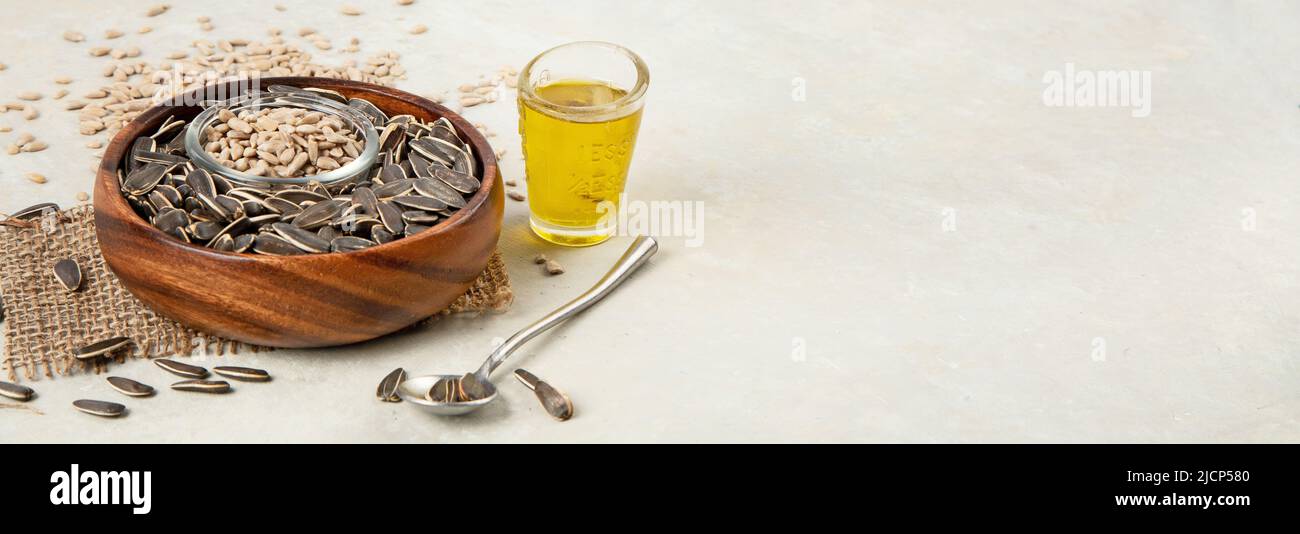 Sunflower oil and sunflower seeds on light background. Organic concept. Healthy food and fats. panorama, copy space Stock Photo