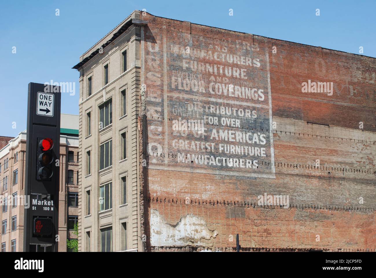 Building and old advertisment on side of the building, next to a red traffic light and one way sign on Market Street in Dallas Texas Stock Photo