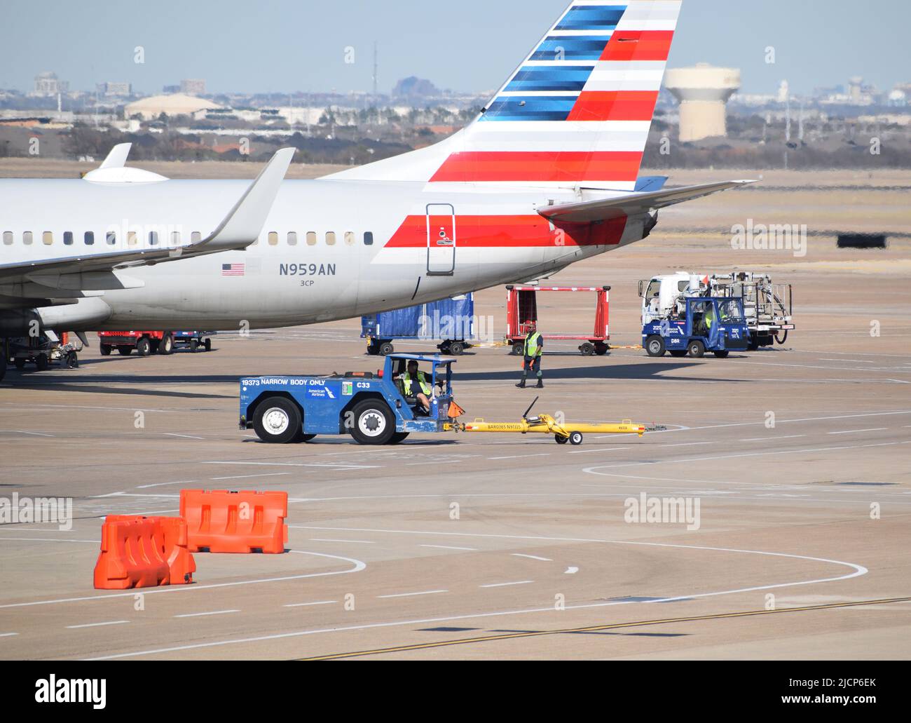 An American Airlines plane being serviced by ramp service agents outside of a terminal at DFW Airport (Dallas-Fort Worth Airport) Stock Photo