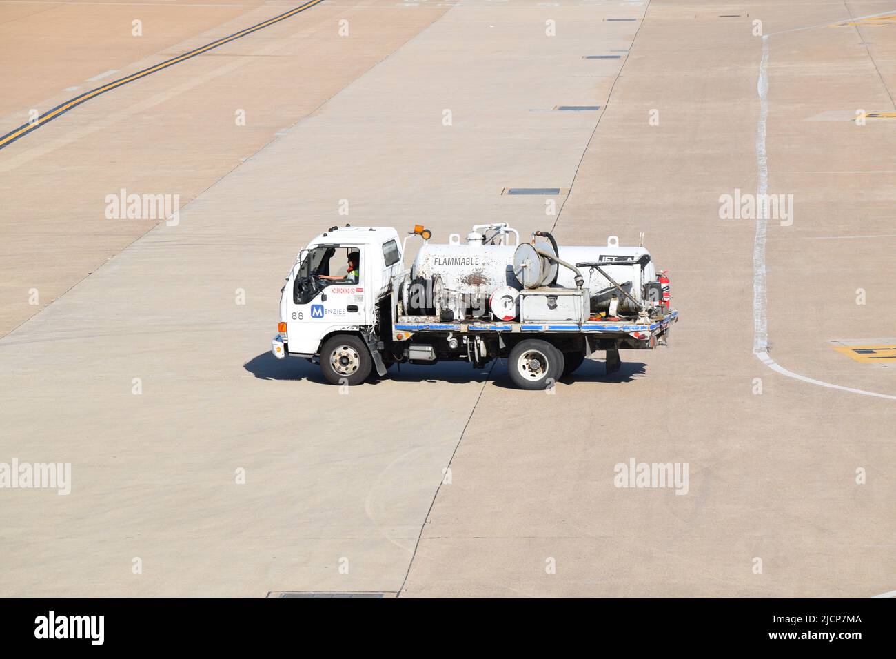 A Menzies Aviation truck after delivering jet fuel; driving away from Terminal E at Dallas Fort Worth International Airport Stock Photo