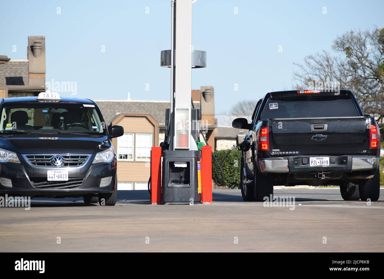 A black Chevrolet Silverado with a 'come and take it' stick in its back window, parked at a gas pump Stock Photo