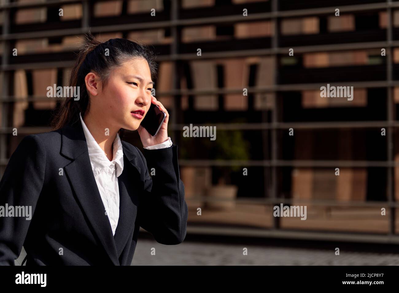 serious asiatic businesswoman talking on the phone Stock Photo
