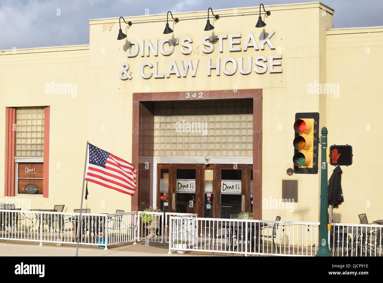 An American flag blows in the wind outside of Dino's Steak & Claw House in historical downtown Grapevine, Texas Stock Photo
