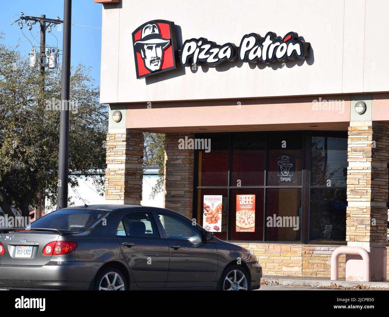 Car parked outside a Pizza Patron pizza store in a Hispanic neighborhood in Irving, Texas Stock