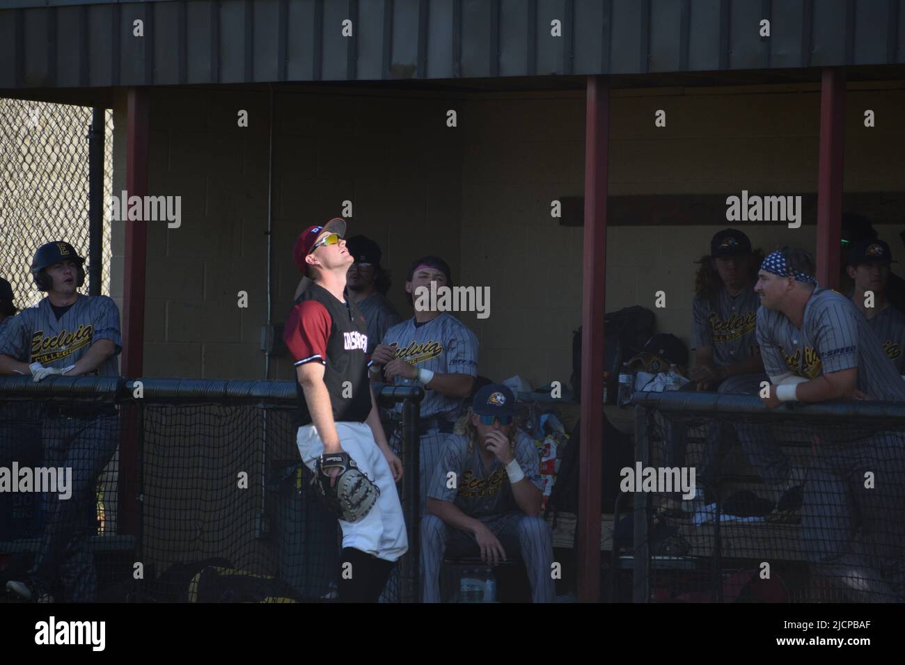 A Dallas Christian College baseball first basemen tracks a foul ball near the opposing teams' dugout Stock Photo