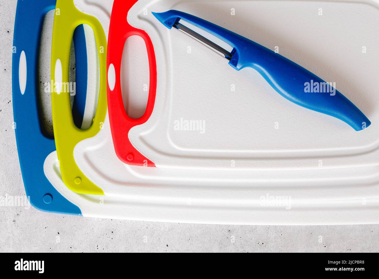 Plastic cutting boards in different colors and sizes, and vegetable