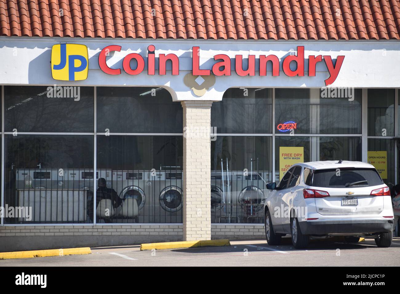 Cars parked in front of JP Coin Laundry laundromat in Irving