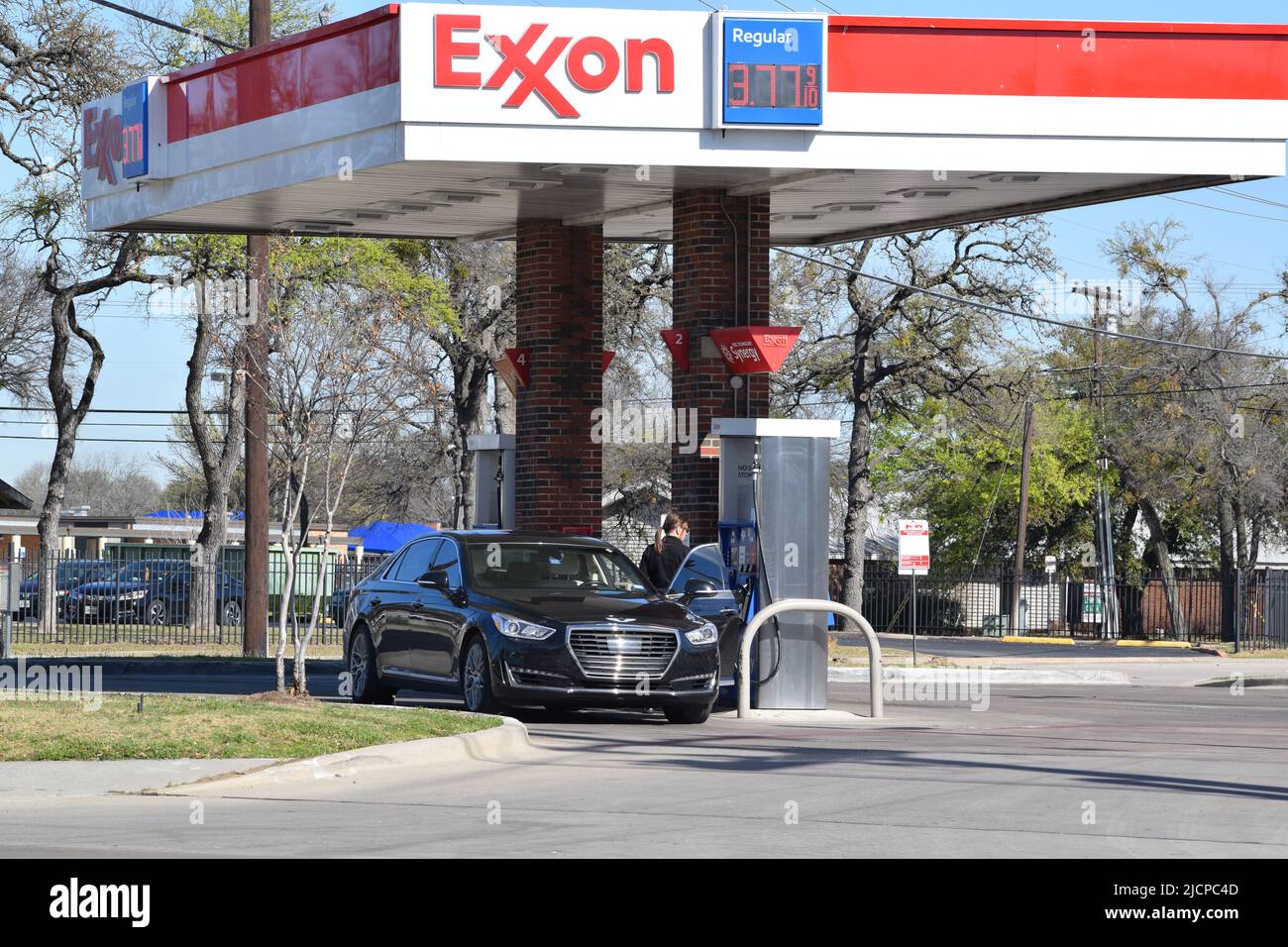Woman preparing to pump gas at an Exxon gas station Stock Photo