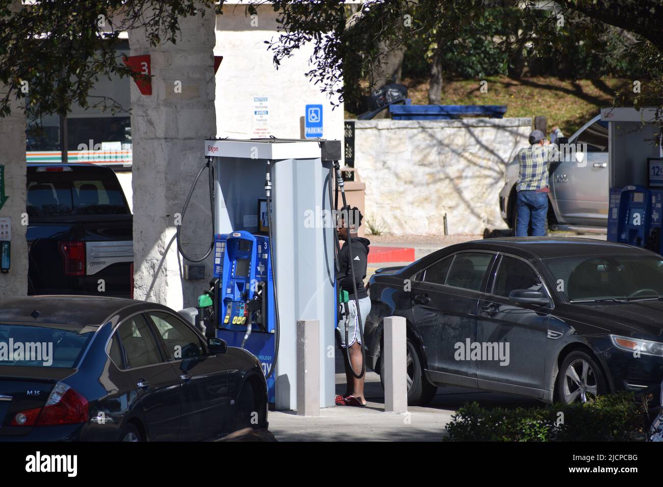Customer pumping gas at a busy Exxon gas station Stock Photo