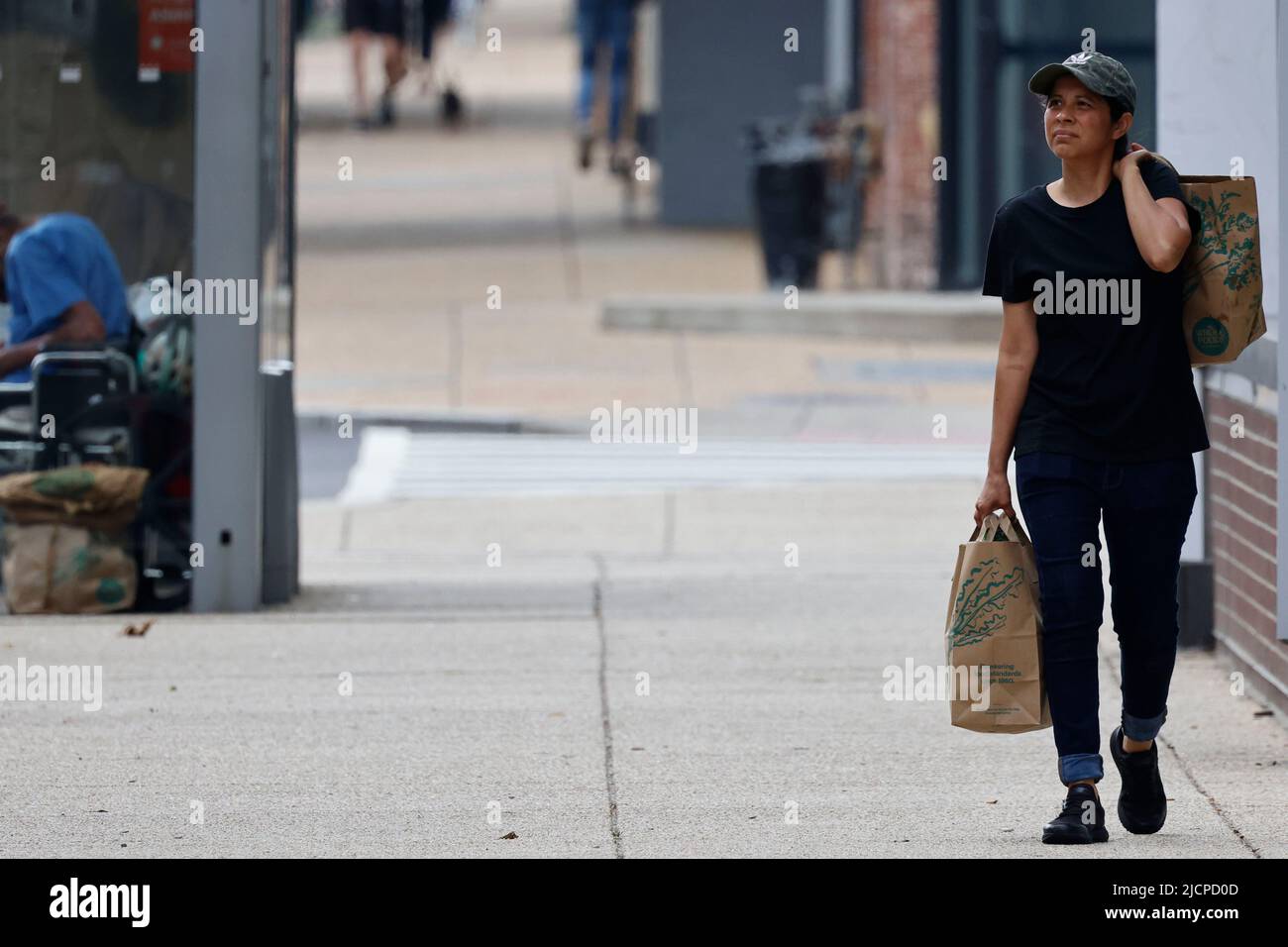 Washington, DC, USA. 14th June, 2022. A woman walks on the street after shopping at a supermarket in Washington, DC, the United States, on June 14, 2022. The U.S. Labor Department reported on Tuesday that producer prices surged 10.8 percent year on year in May, the latest sign of mounting inflation pressure, which could prompt the Federal Reserve to raise rates more aggressively. Credit: Ting Shen/Xinhua/Alamy Live News Stock Photo