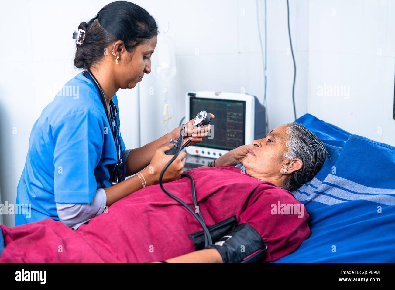 Nurse or doctor checking bp or blood pressure of senior sick patient at hospital on bed - concept of treatment, routine checkup and healthcare Stock Photo