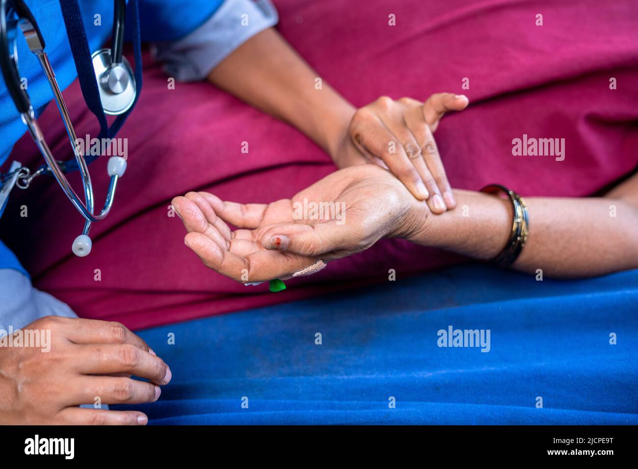 Close shot of doctor checking pulse rate to sick women by holding hands at hospital - concept of treatment, routine and medical. Stock Photo