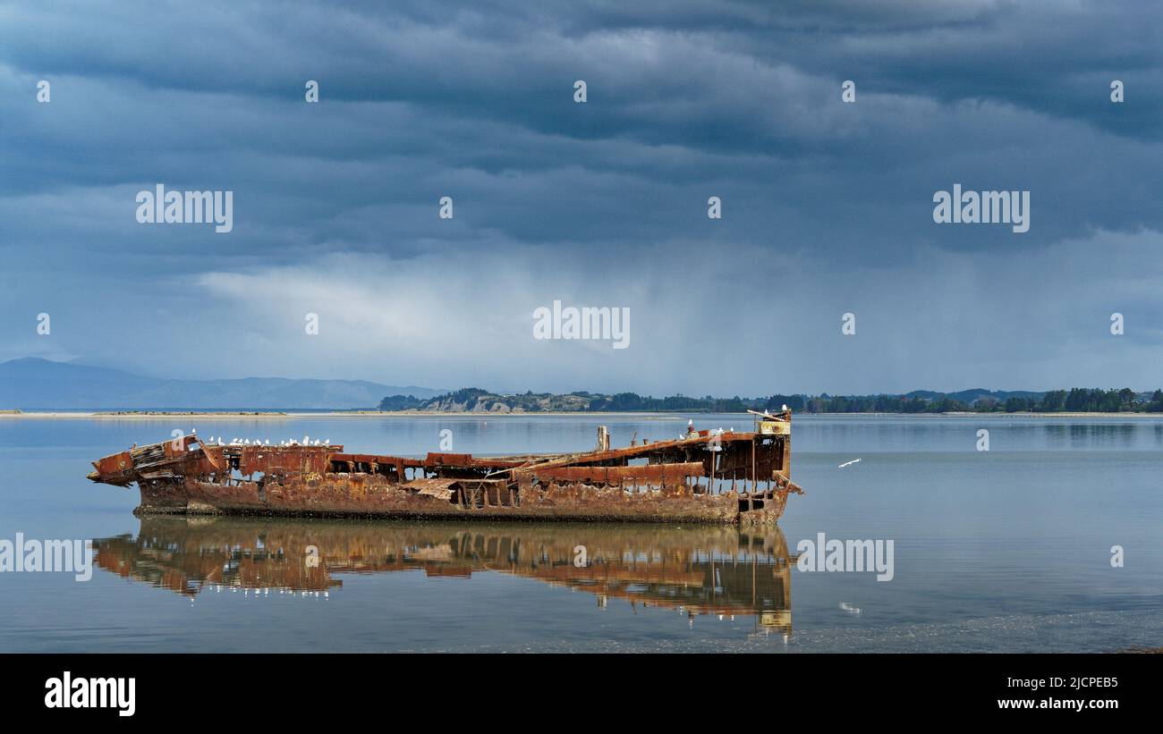 Janie Seddon shipwreck with a rain storm in the background, Motueka, Tasman region, Aotearoa / New Zealand Stock Photo