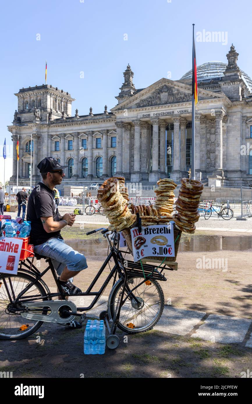 man on cycle selling pretzels, or Brezeln, in Platz der Republik near the Reichstag Building in Berlin, Germany Stock Photo