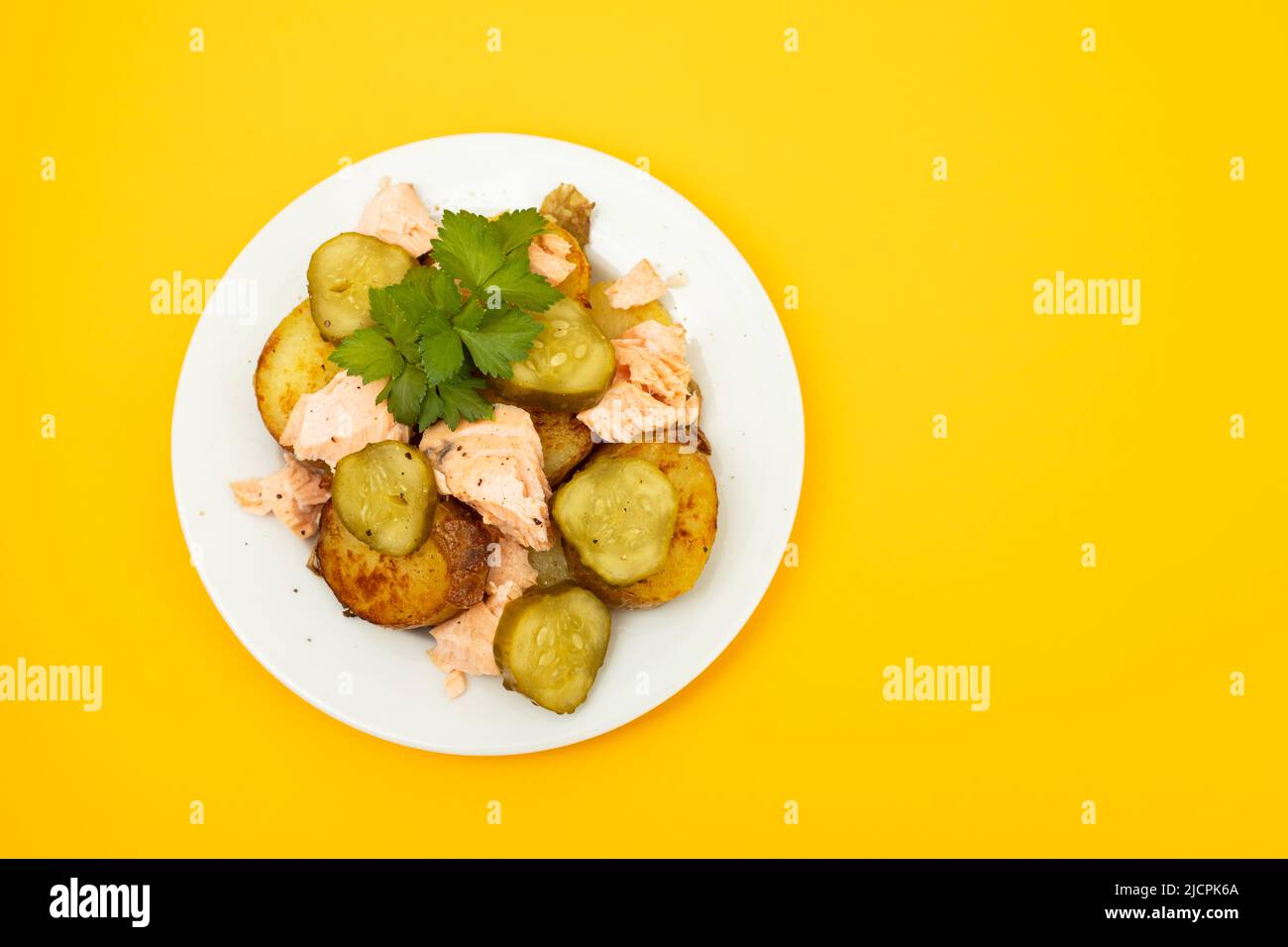fresh baked salmon with fried potato and cucumber on plate Stock Photo
