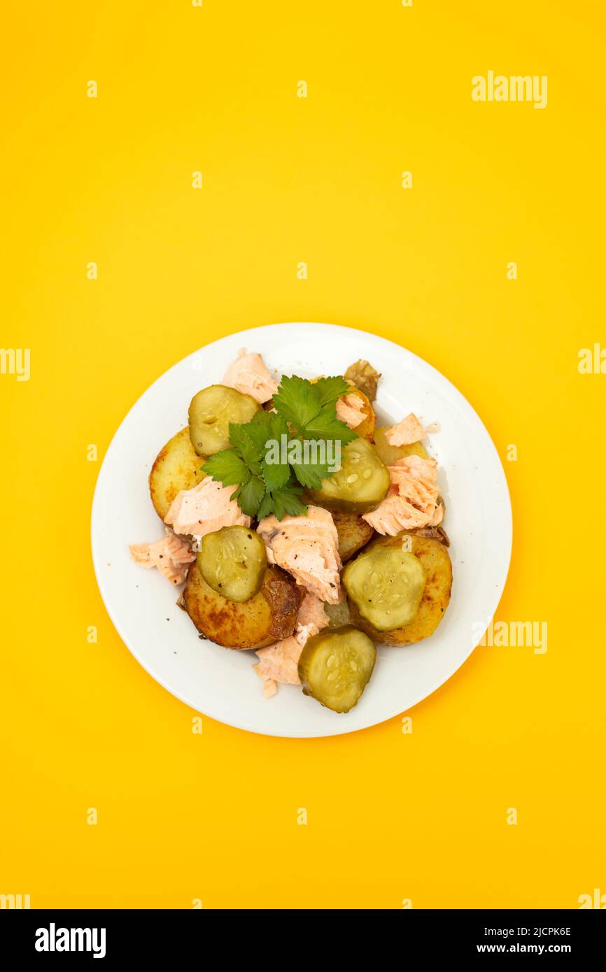 fresh baked salmon with fried potato and cucumber on plate Stock Photo