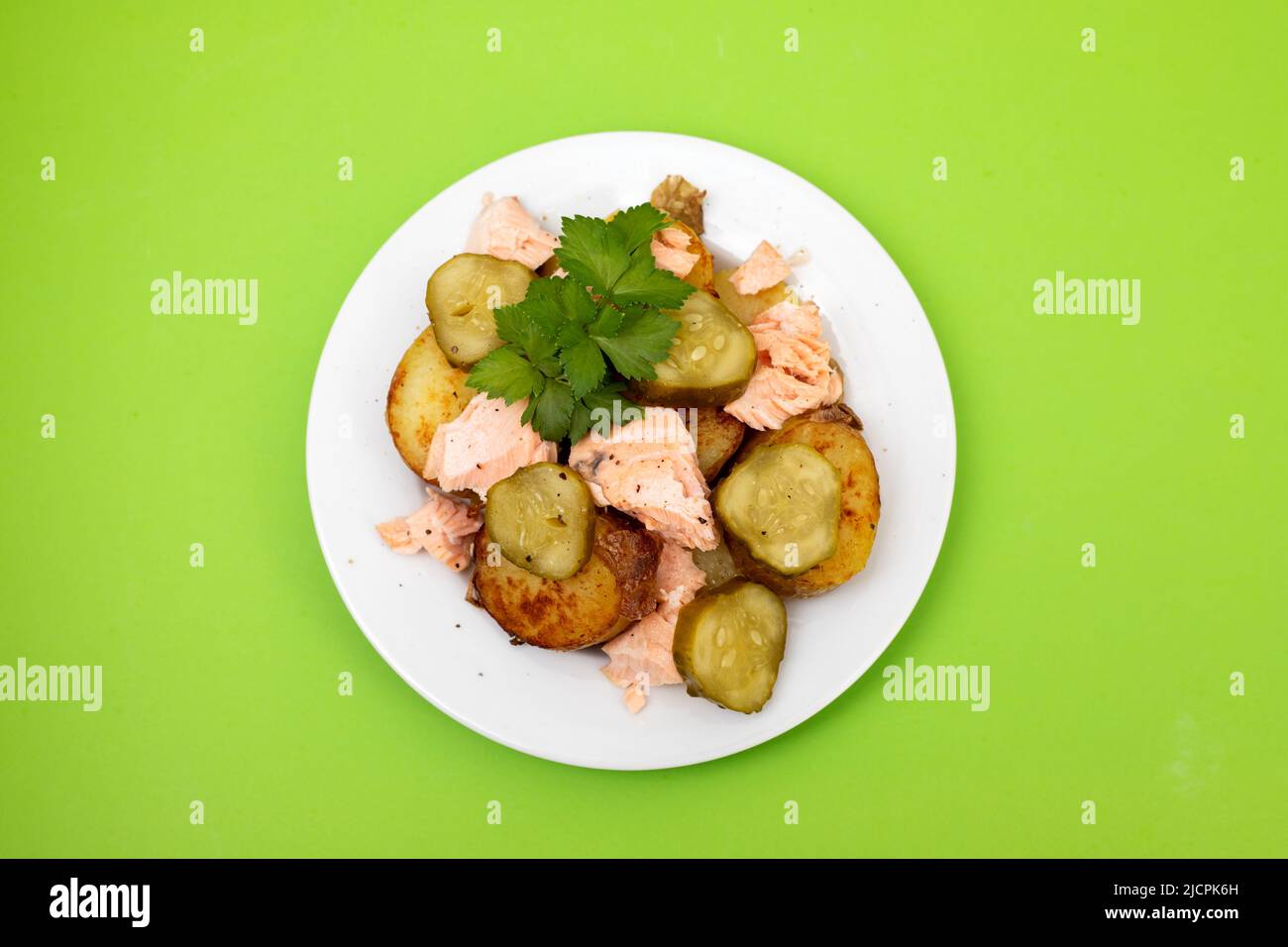 fresh baked salmon with fried potato and cucumber on plate Stock Photo