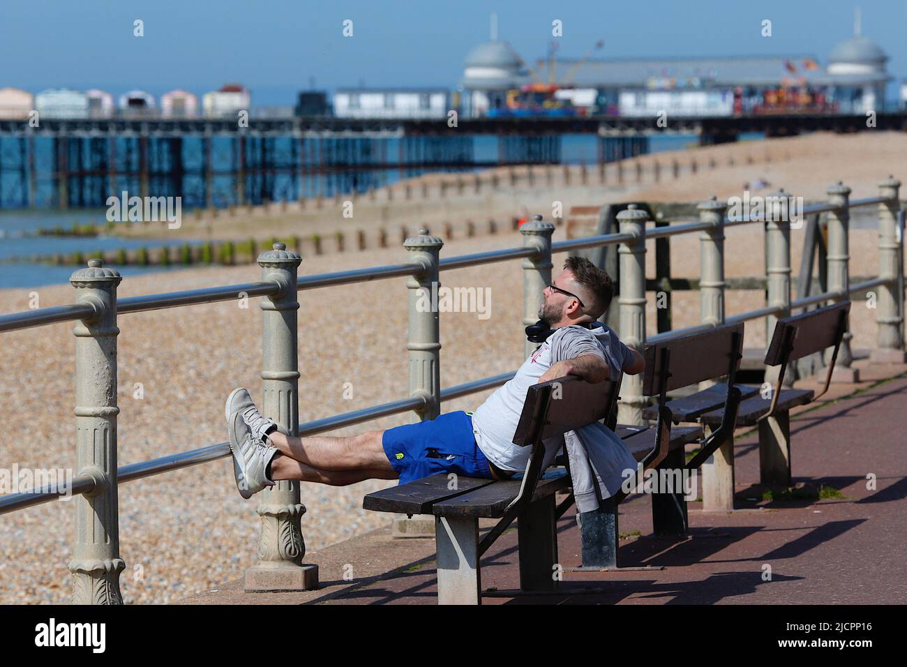 Hastings, East Sussex, UK. 15 Jun, 2022. UK Weather: Hot and sunny at the seaside town of Hastings in East Sussex as Brits enjoy the warm weather today along the seafront promenade. A man sitting on a bench enjoying the morning weather. Photo Credit: Paul Lawrenson /Alamy Live News Stock Photo