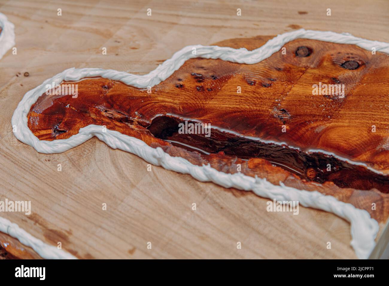 Closeup of dried epoxy resin in wood table. Process of making a craft