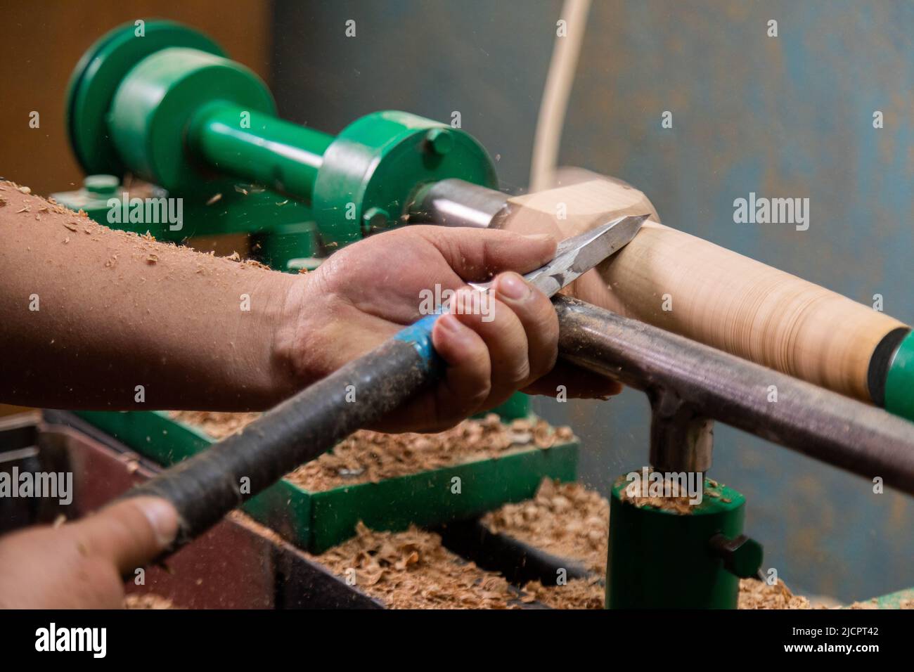 Closeup of carpenter turning wood on a lathe. Person carving chisel candlestick on a lathe Stock