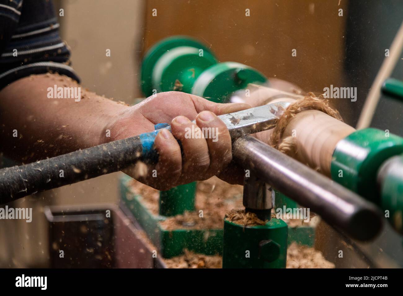 Closeup of carpenter turning wood on a lathe. Person carving chisel candlestick on a lathe Stock