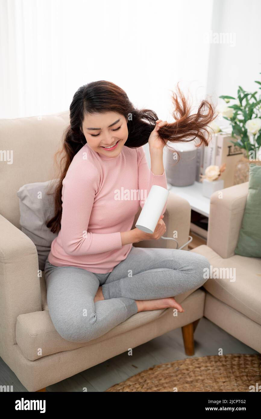 Beautiful girl drying her hair with hairdryer Stock Photo - Alamy