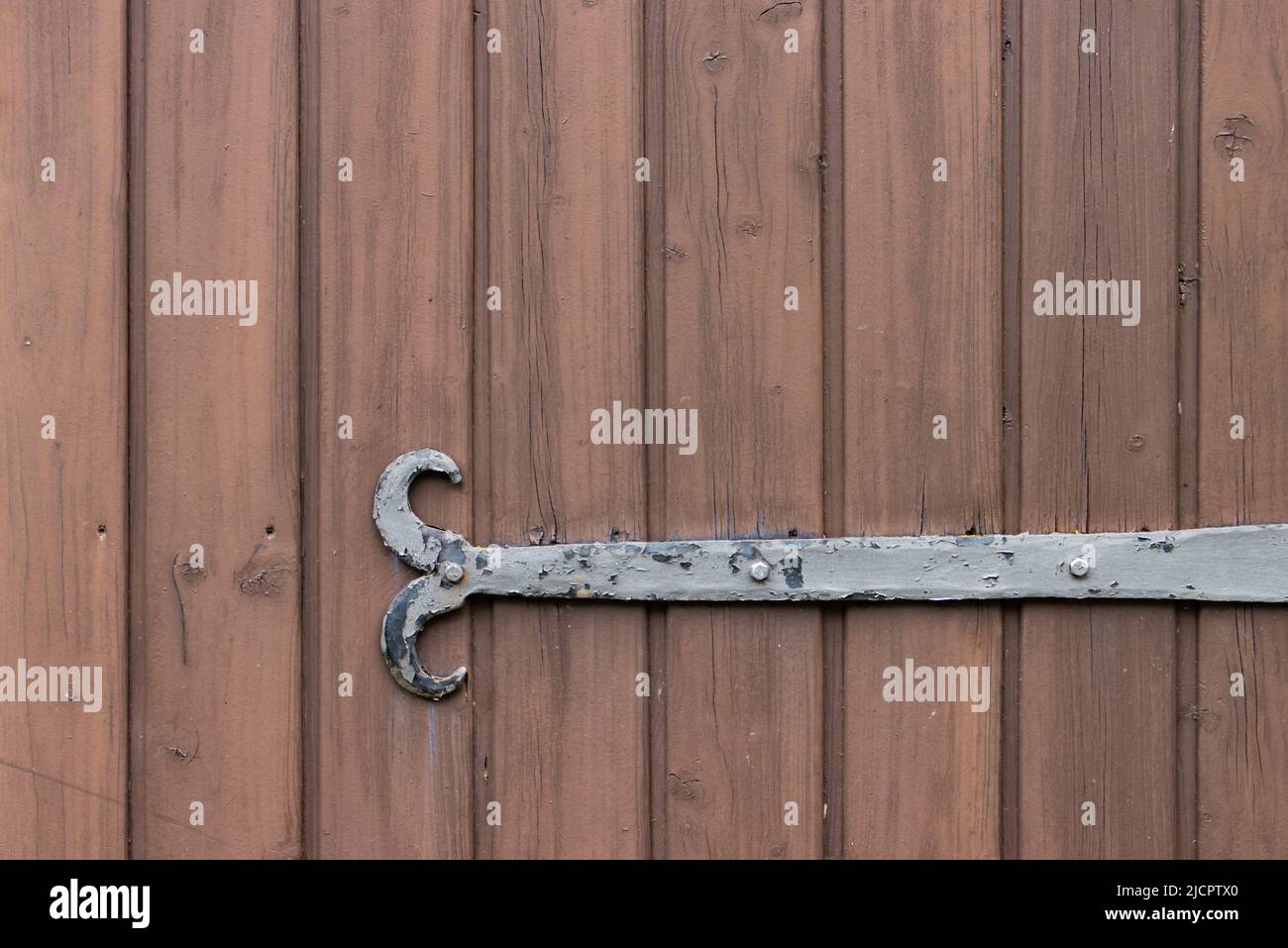 Old metal fitting on a wooden door for background with copy space Stock Photo
