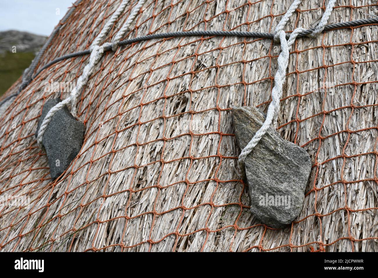 Close up of thatched roof and weighted stones on norse kiln, Shawbost, Isle of Lewis, Outer Hebrides, Scotland, UK. Stock Photo