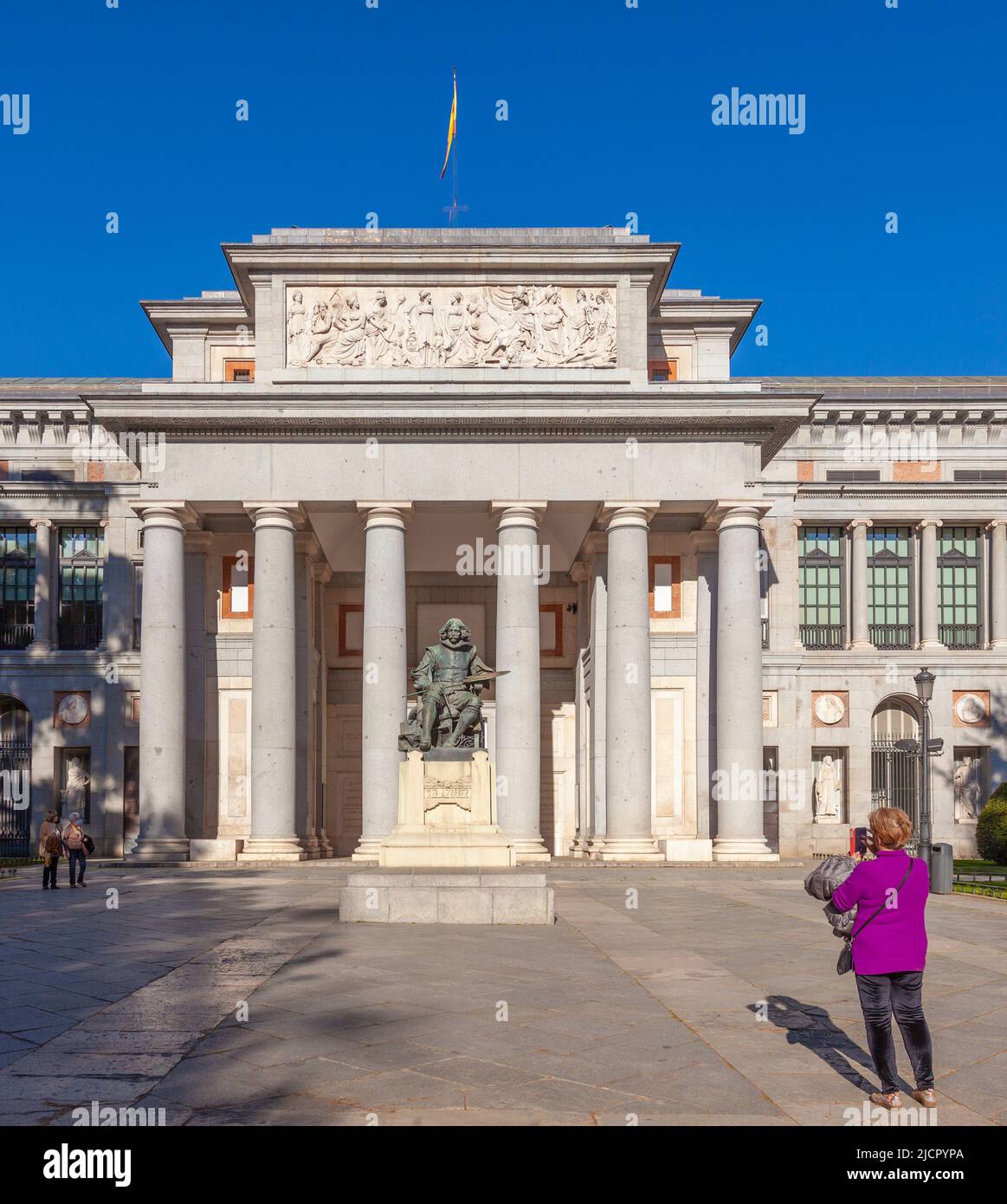 Madrid, Spain - 25th April 2022. A woman photographing the Statue of Velázquez (1899, Aniceto Marinas Garcia) in front of the Prado Museum, Madrid. Stock Photo