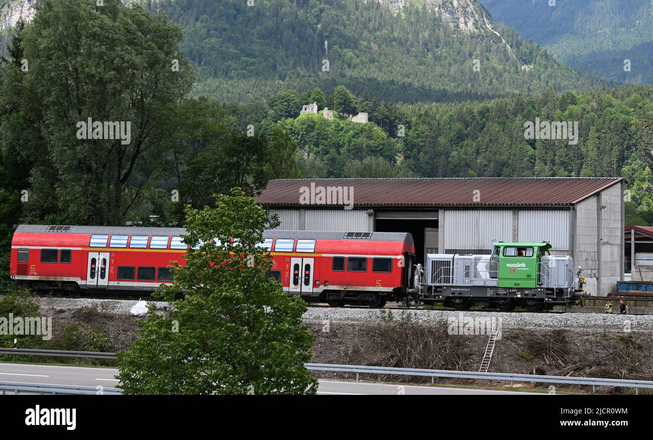 Garmisch Partenkirchen, Germany. 15th June, 2022. A wagon from the crashed regional train is removed by a locomotive. After the train accident with dead and injured, the recovery of the last parts of the train is carried out with a special rail crane. Credit: Angelika Warmuth/dpa/Alamy Live News Stock Photo