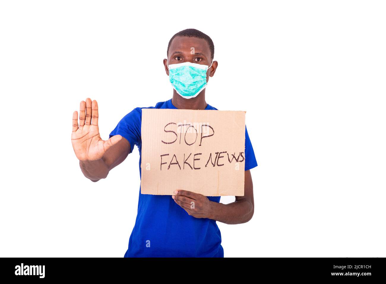 a young man in a blue tee shirt standing on a white background wearing