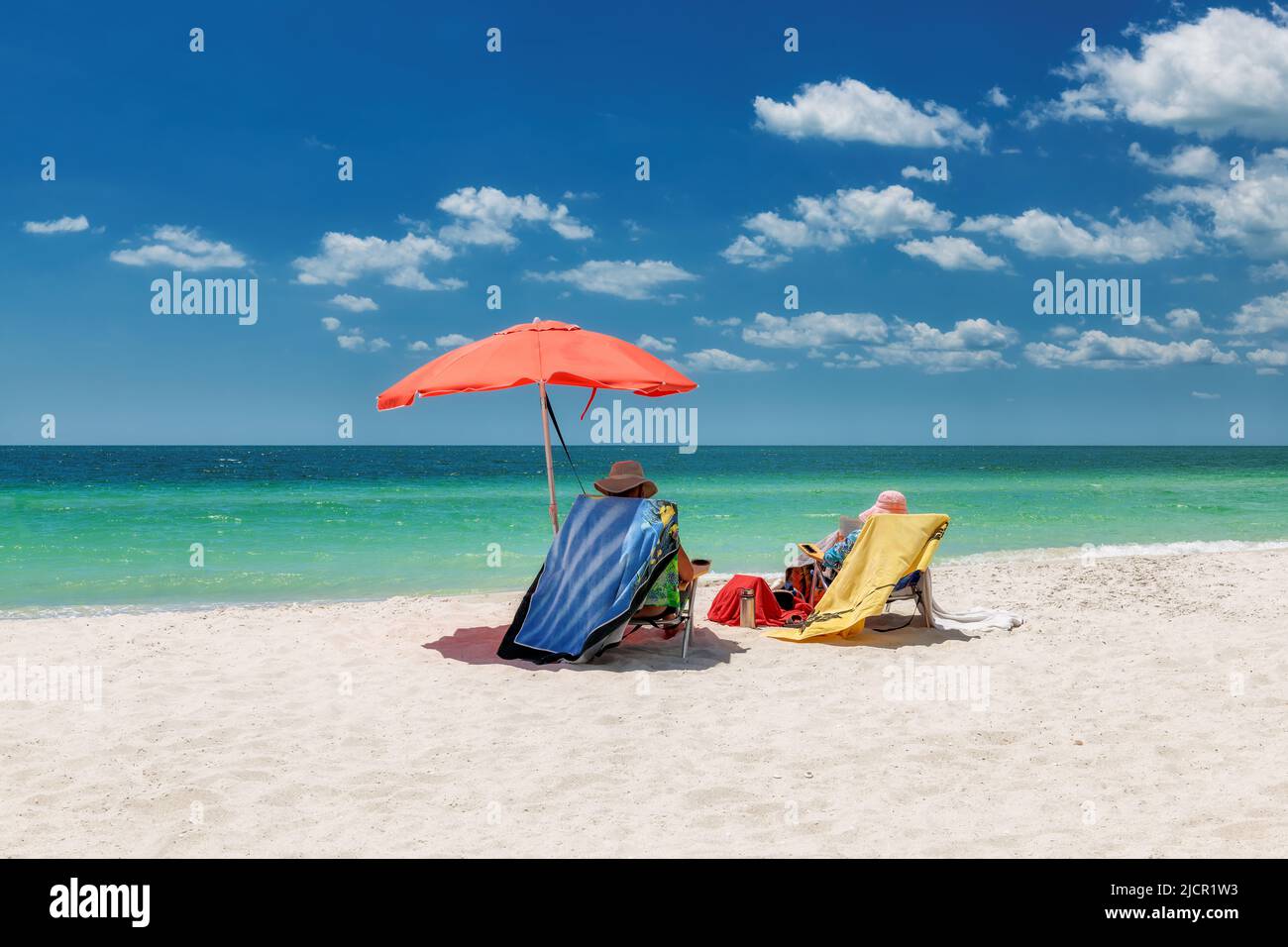 Beautiful white sand beach with umbrella and lounge beach chairs with beach accessories in Naples Beach, Florida, USA Stock Photo