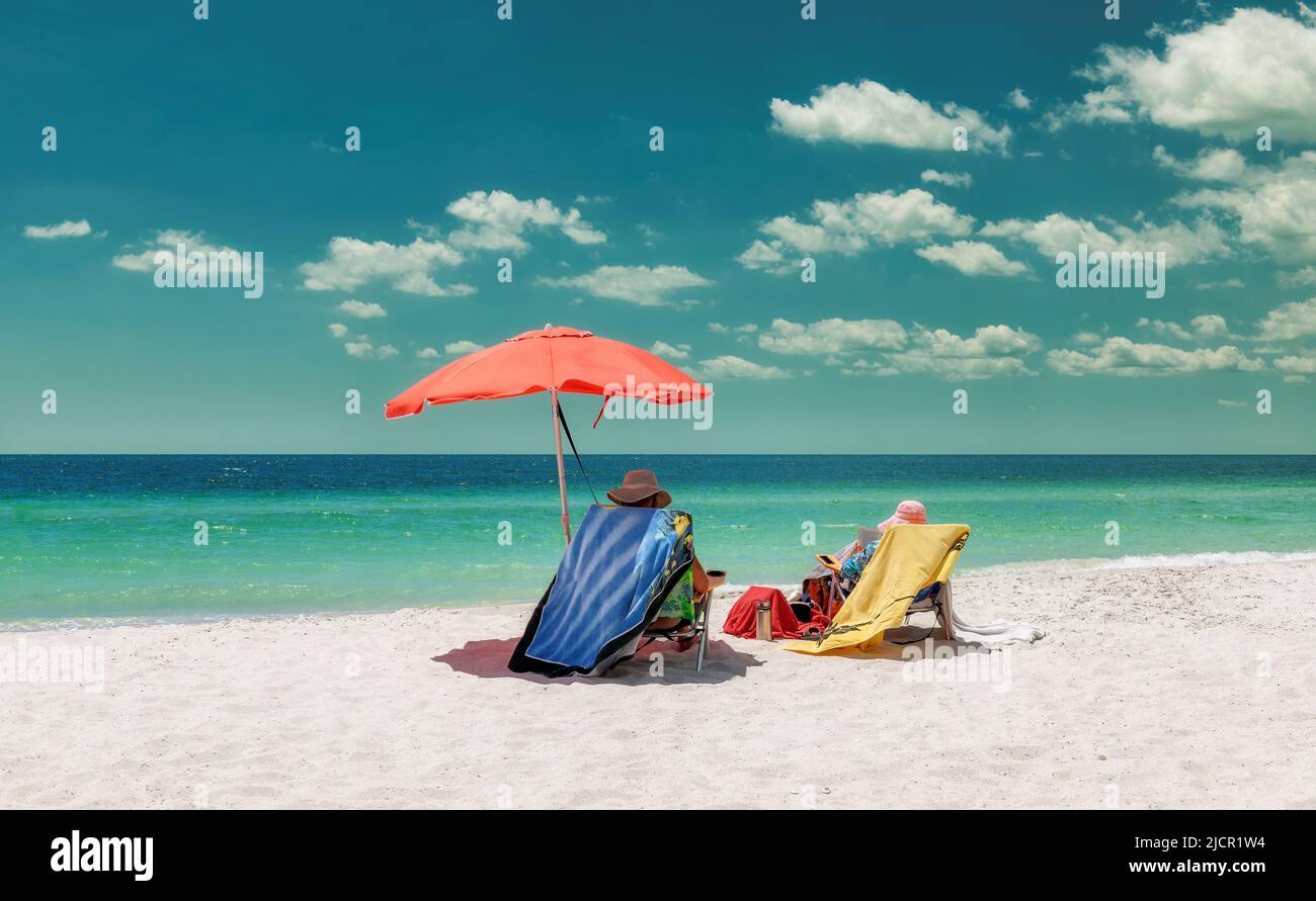 Beautiful white sand beach with umbrella and lounge beach chairs with beach accessories in Paradise island. Vintage processed. Stock Photo