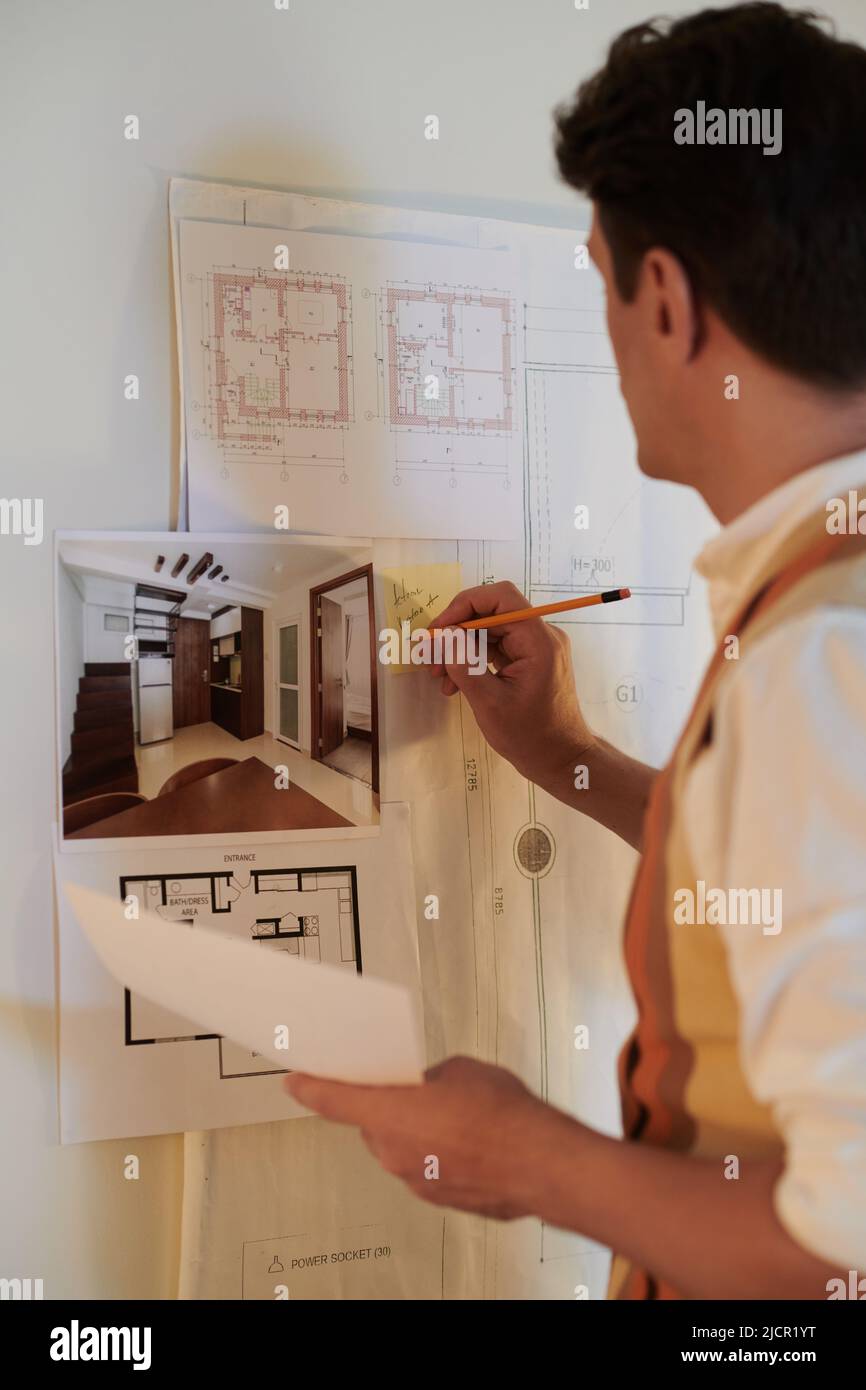 Architect writing on sticky note on mood board he created for project