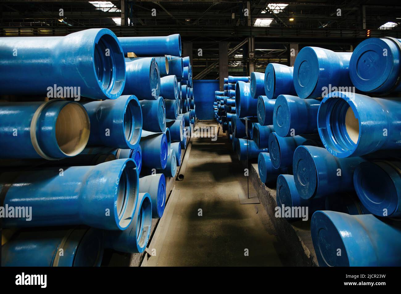 New blue colored cast iron pipes with caps for pipeline construction in
