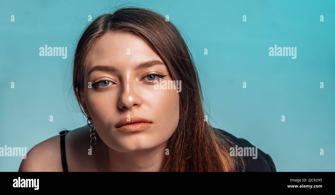Portrait of a beautiful woman with clean face on blue background.  Stock Photo