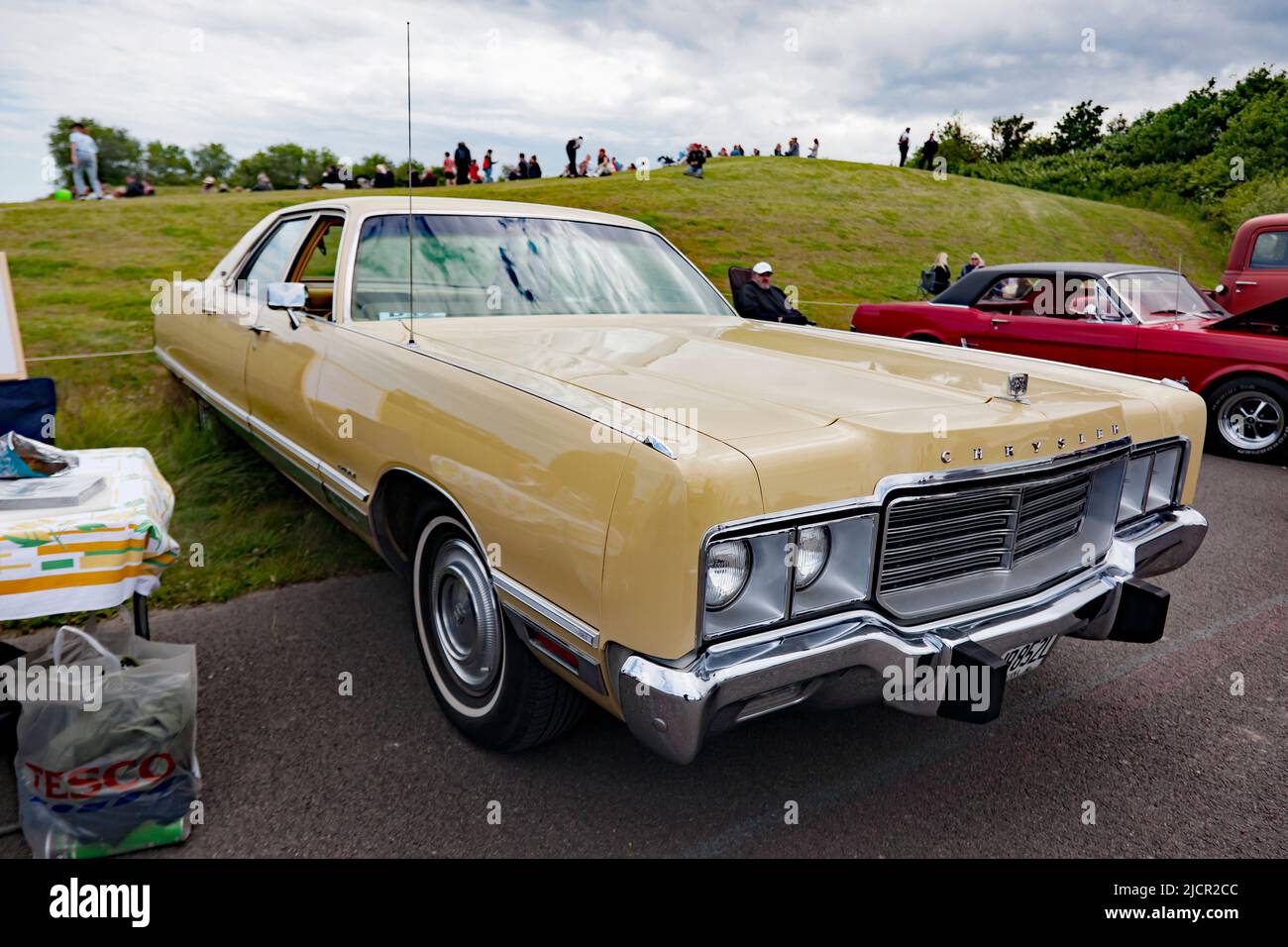 Three-quarters front view of a Gold, 1972, Chrysler New Yorker four-door hardtop, on display at the Deal Classic Car Show 2022 Stock Photo