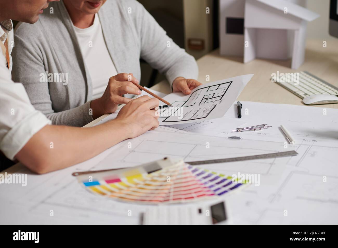 Architect explaining details of house floor plant to client at meeting ...