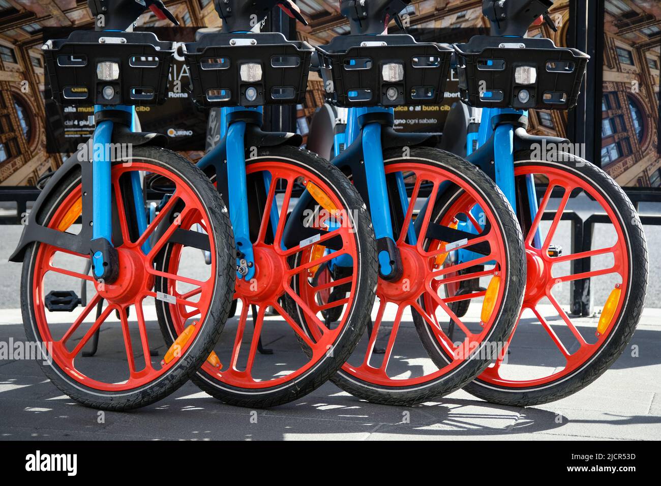 Four rental bicycles lined up with red rims on sidewalk in Rome, Italy. Stock Photo