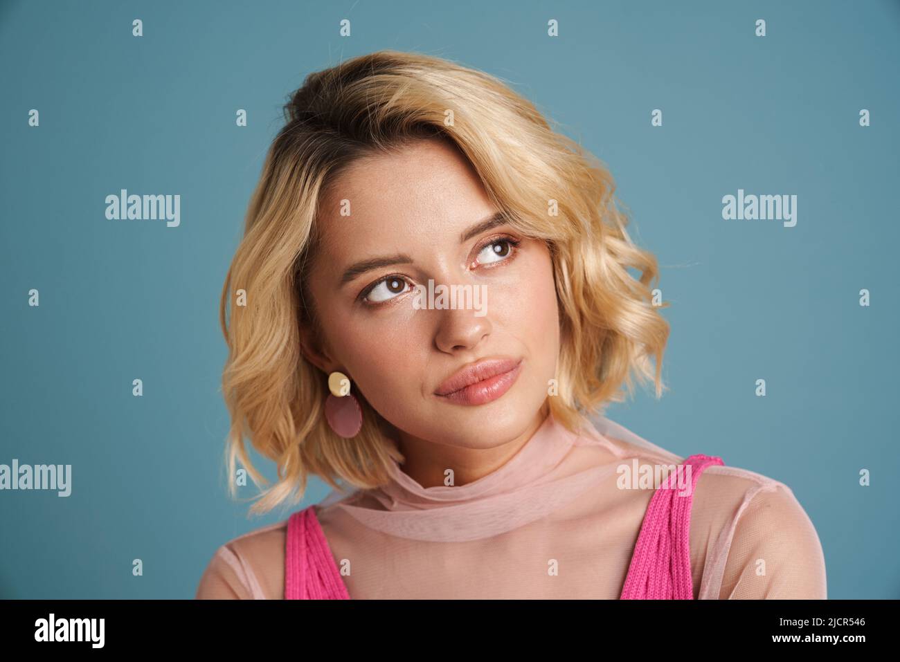 Young white woman with blonde hair posing and looking aside isolated ...