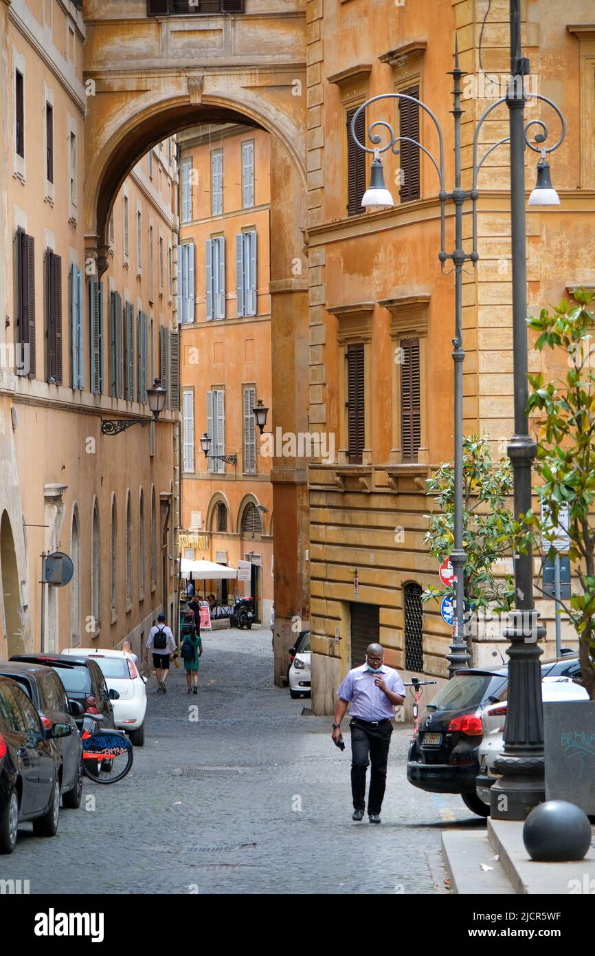 Rome, Italy - June 6, 2022: Pedestrians walk through narrow streets of Rome, Italy. Stock Photo
