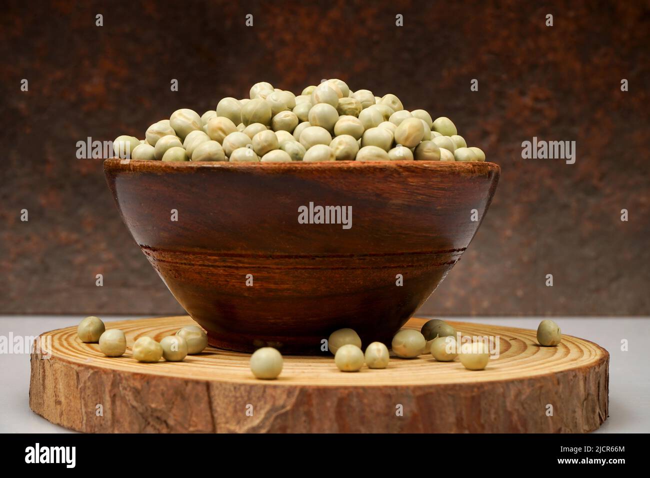 Uncooked dried green peas, also known as vatane in Marathi. in a ceramic bowl on white background Stock Photo