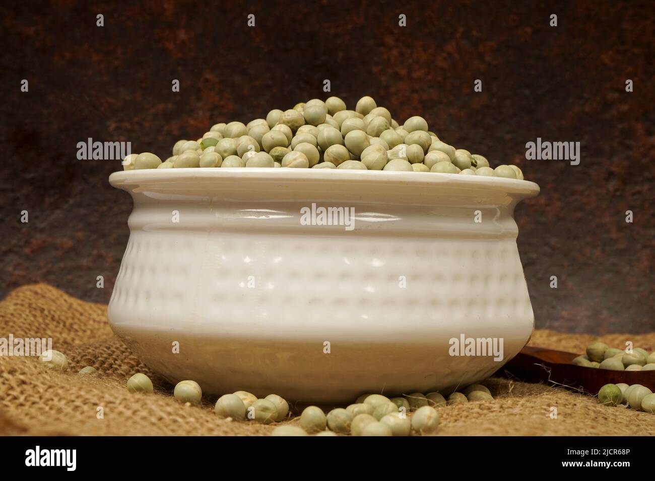 Uncooked dried green peas, also known as vatane in Marathi. in a ceramic bowl on white background Stock Photo