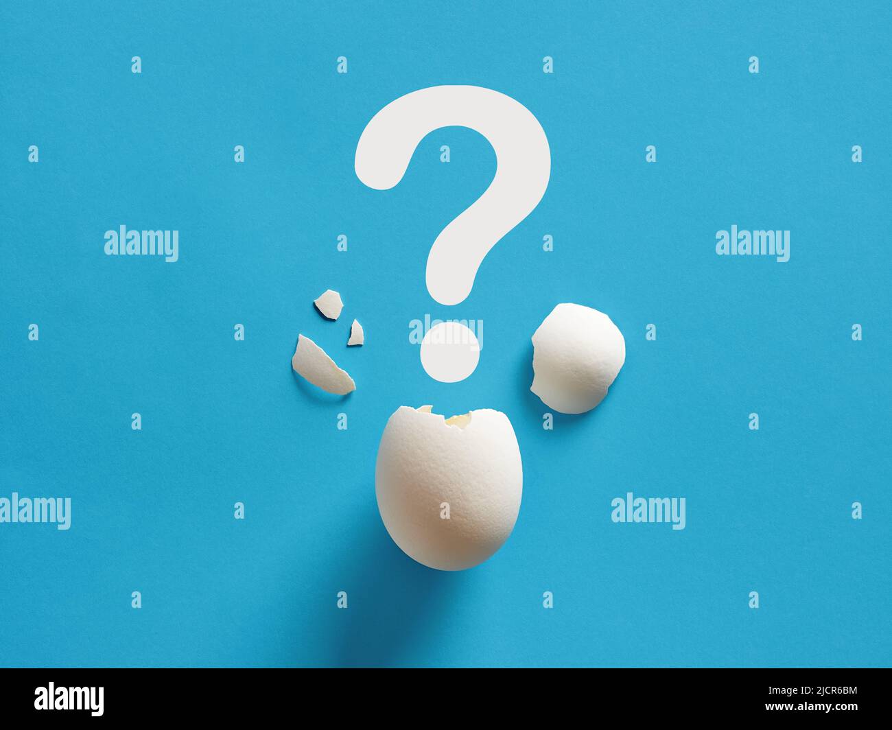 Cracked white chicken egg shell with question mark symbol. Surprise, mystery, uncertainty or baby gender prediction concepts. Stock Photo
