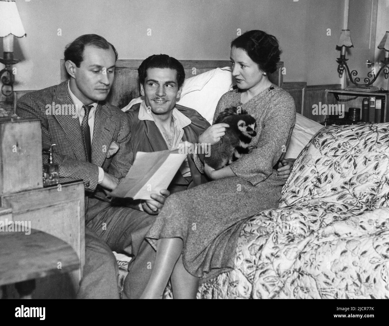ROBERT DOUGLAS in December 1934 being coached by an injured LAURENCE OLIVIER for the part of Tony Cavendish in the original London stage presentation of THEATRE ROYAL (THE ROYAL FAMILY in US) written by George S. Kaufman and Edna Ferber and directed by no0el Coward at the Lyric Theatre, Shaftesbury Avenue, London. Looking on is Olivier's 1st wife JILL  ESMOND holding their pet Lemur TONY Stock Photo