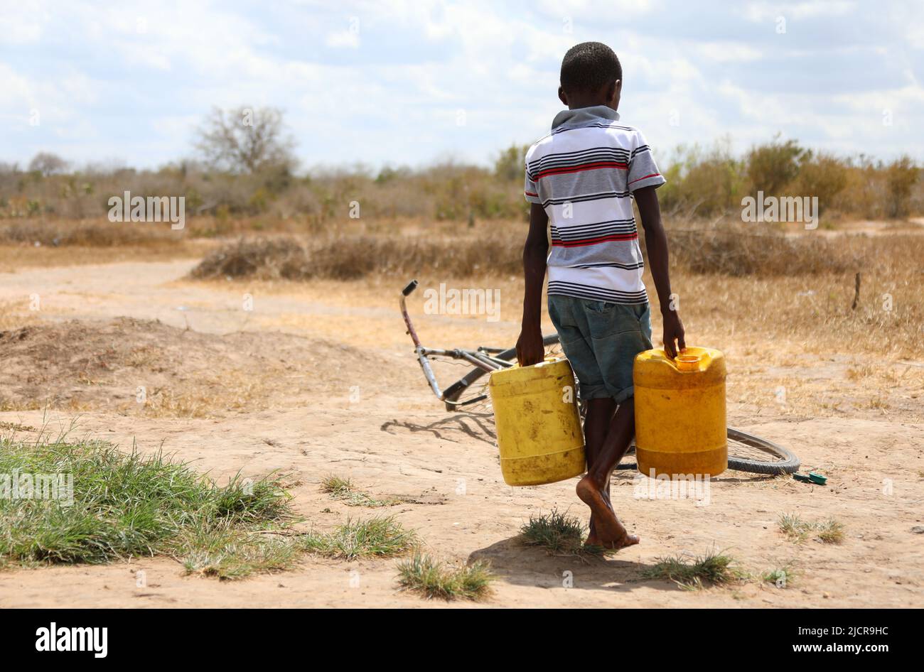 Kilifi, Kenya. 23rd Mar, 2022. A boy carries buckets of water in Kidemu