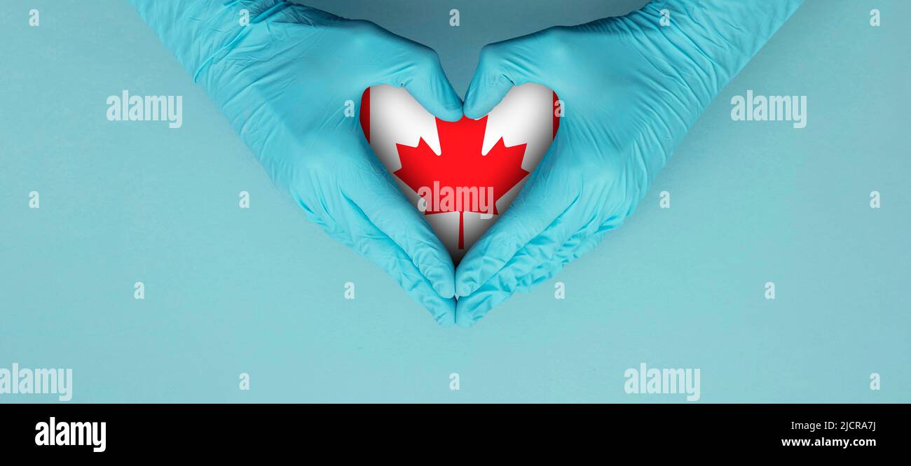 Doctors hands wearing blue surgical gloves making hear shape symbol