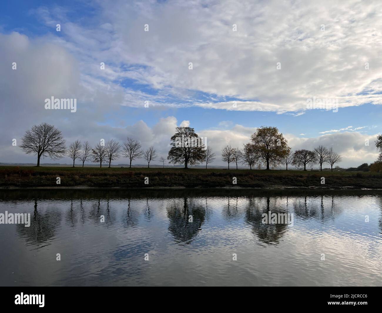 Trees and cloudscape on water reflection, Saint-Valery sur Somme, France Stock Photo