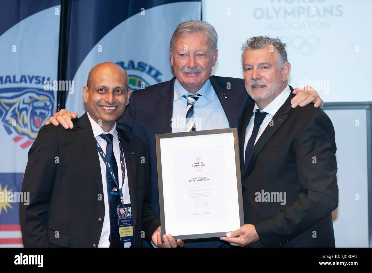 Lausanne, Switzerland. 13th June, 2022. John Bertrand from Australia (in the middle) received the 'World Olympians' certificate for having won several competitions including the famous America's Cup in 1983, on his right is Mr. Joel Bouzout (a French sportsman, world champion in 1987 in modern pentathlon) and on his left the Indian Malov Shroff (the President of the Asian Sailing Federation) during the prize-giving ceremony to announce the 1st World Cup of Sailing Football. (Photo by Eric Dubost/Pacific Press) Credit: Pacific Press Media Production Corp./Alamy Live News Stock Photo
