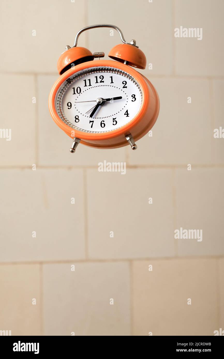 Orange vintage style alarm clock flying in the bathroom Stock Photo Alamy